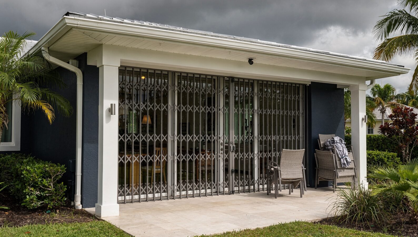 South Florida rental home with closed accordion storm shutters and secured exterior ahead of an approaching hurricane